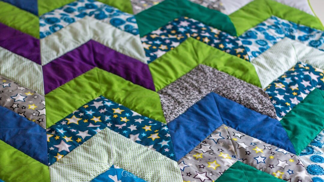 a close up of a quilt on a bed